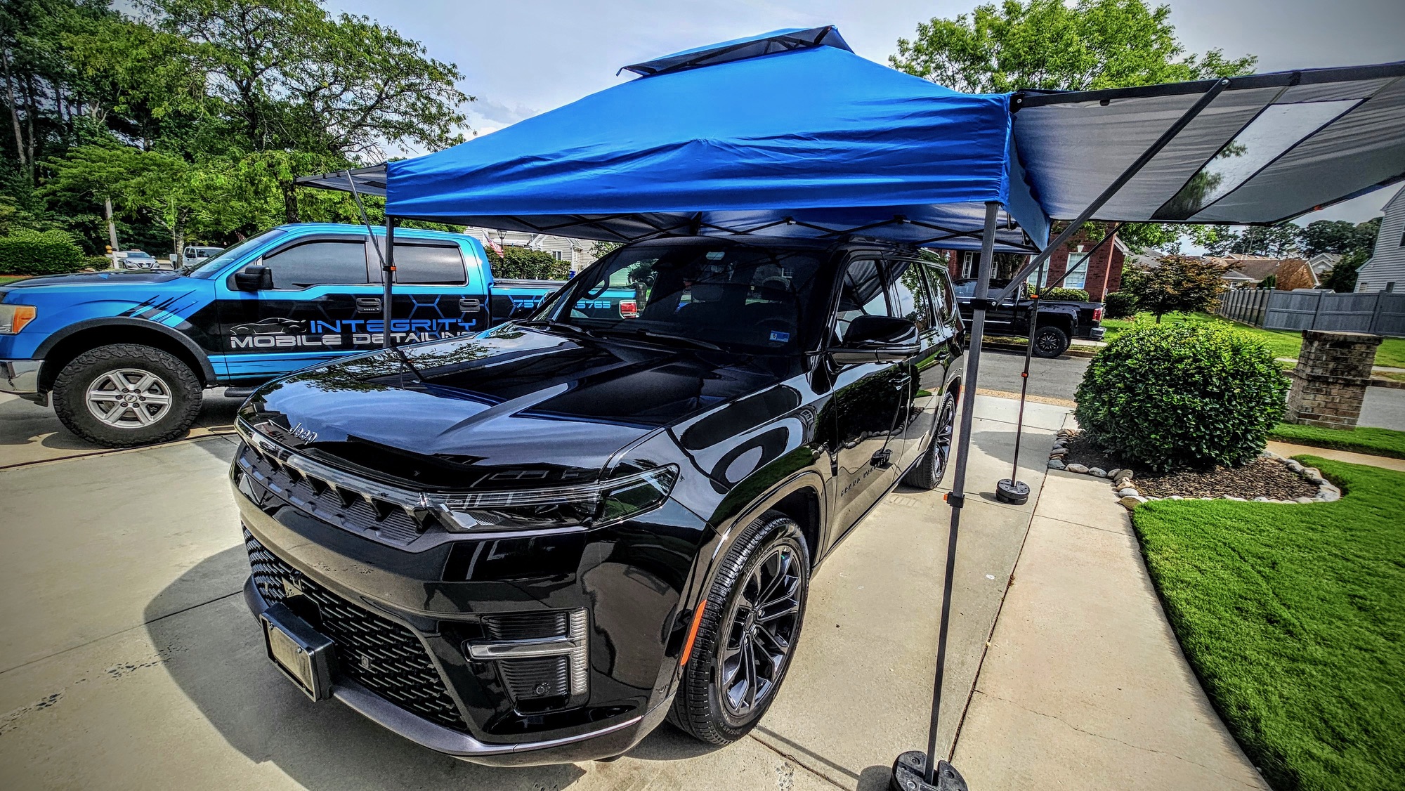 Black Jeep receiving mobile detailing under an Integrity canopy