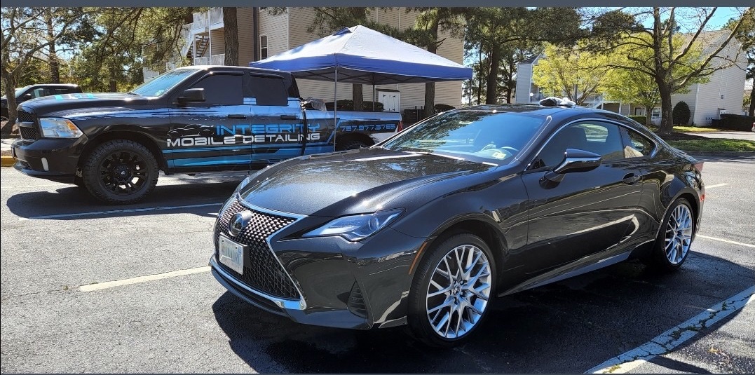 Integrity Mobile Detailing truck and canopy beside a Lexus at a customer location
